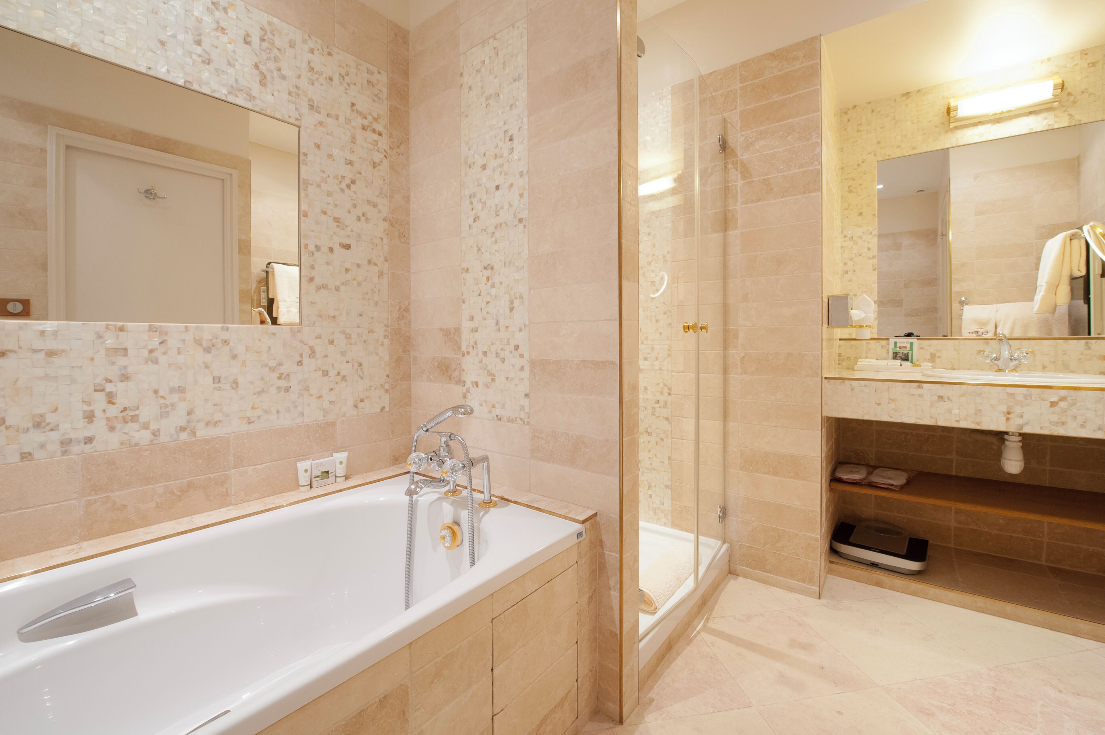 Une salle de bain moderne dotée d’une grande baignoire, d’une douche à parois de verre et d’un meuble-lavabo avec un miroir.