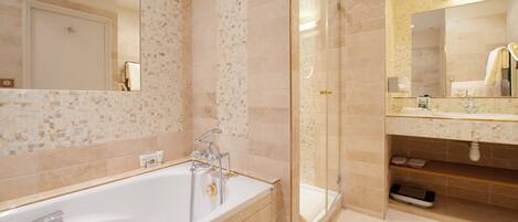 Une salle de bain moderne dotée d’une grande baignoire, d’une douche à parois de verre et d’un meuble-lavabo avec un miroir.