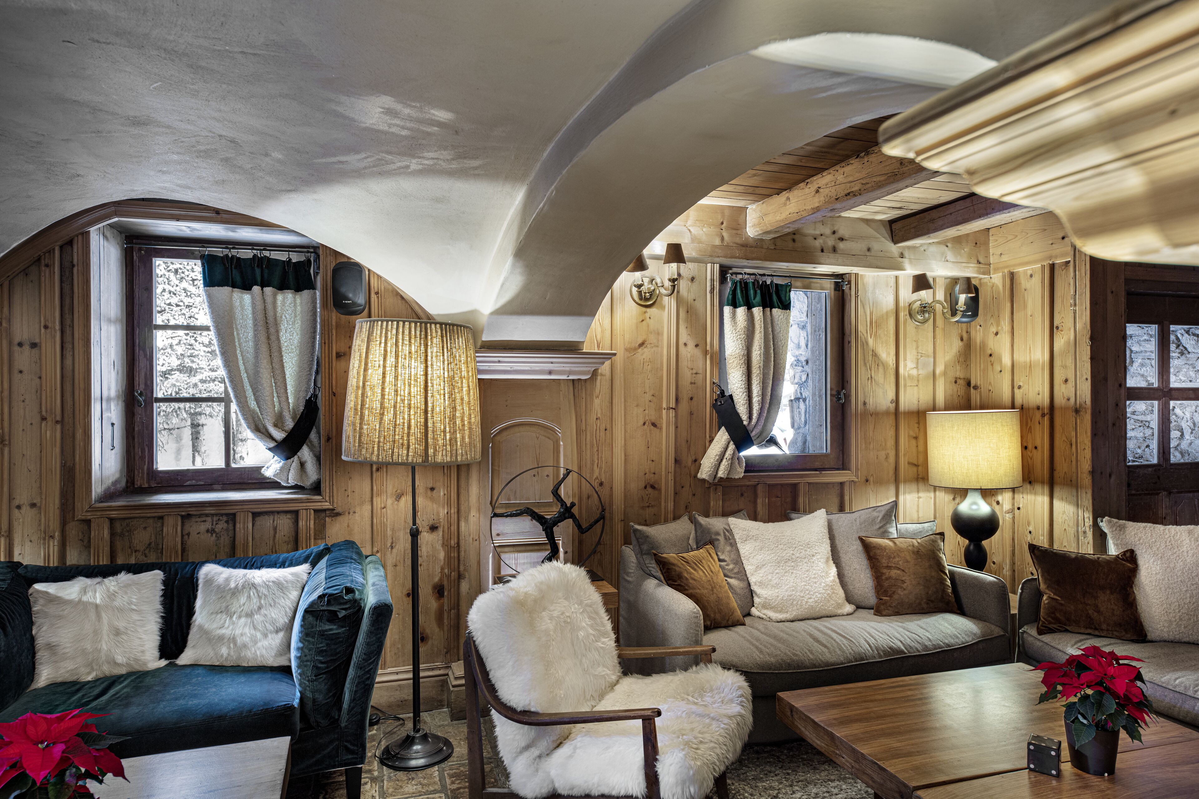Un interior acogedor de cabaña de troncos, con un sofá, un sillón y una mesa de centro de madera.