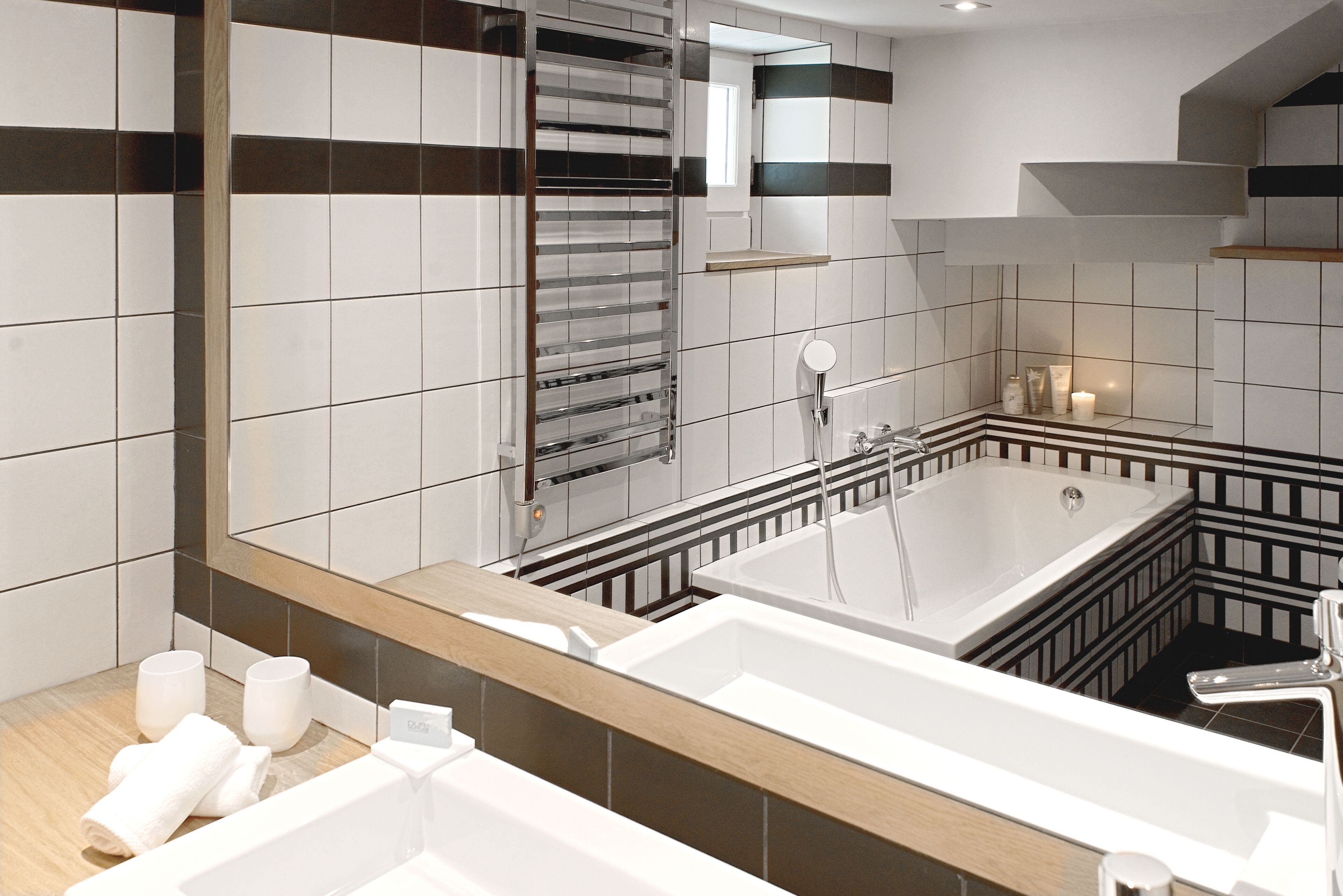 A modern bathroom with a large bathtub, a glass shower enclosure, and a wooden vanity.