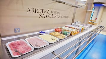 A buffet setup with various food items and a wall with a sign.