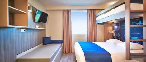 A hotel room with a bed, a desk, a TV, a window, and a bunk bed.