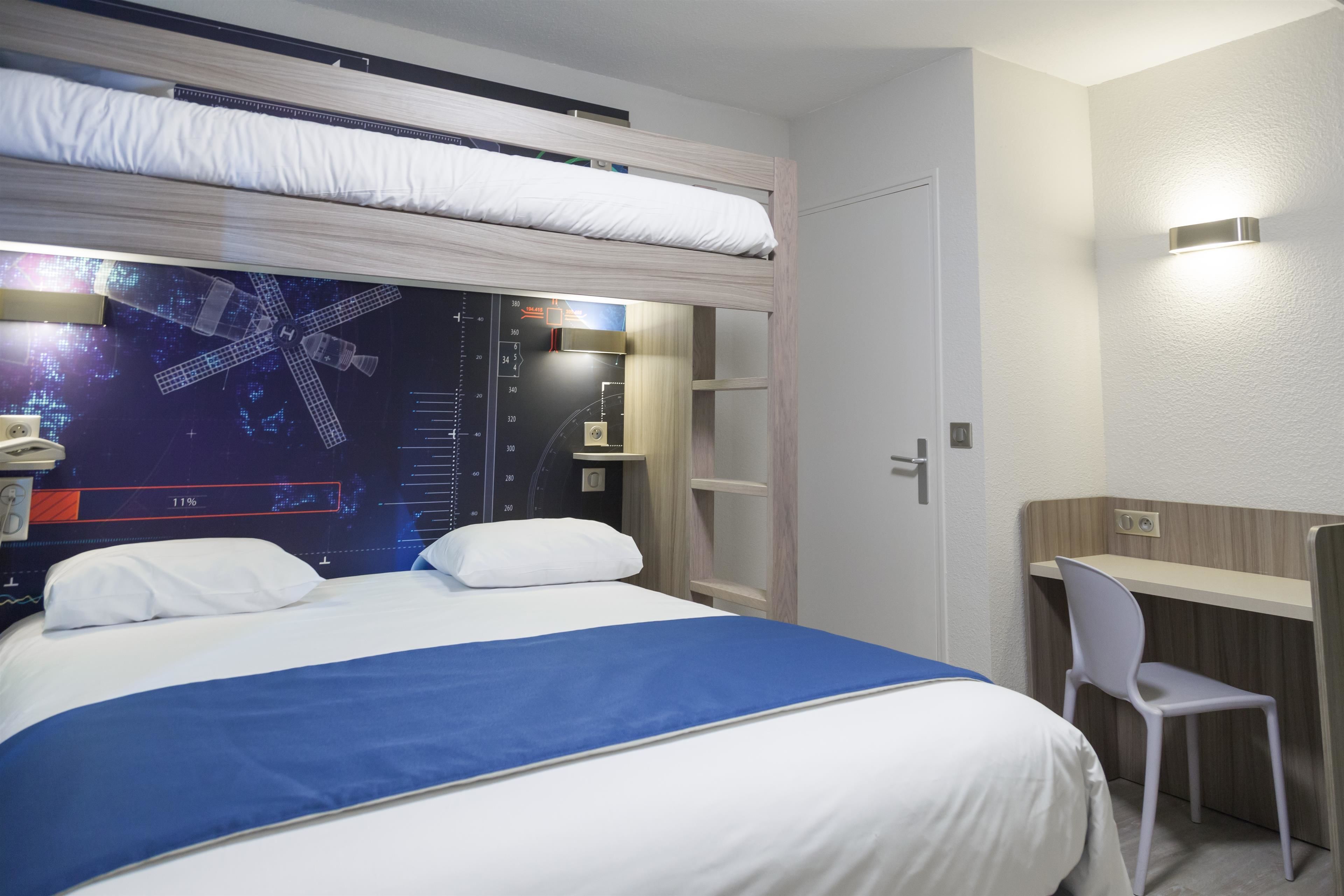 Una habitación de hotel moderna con una litera, un escritorio y una silla.