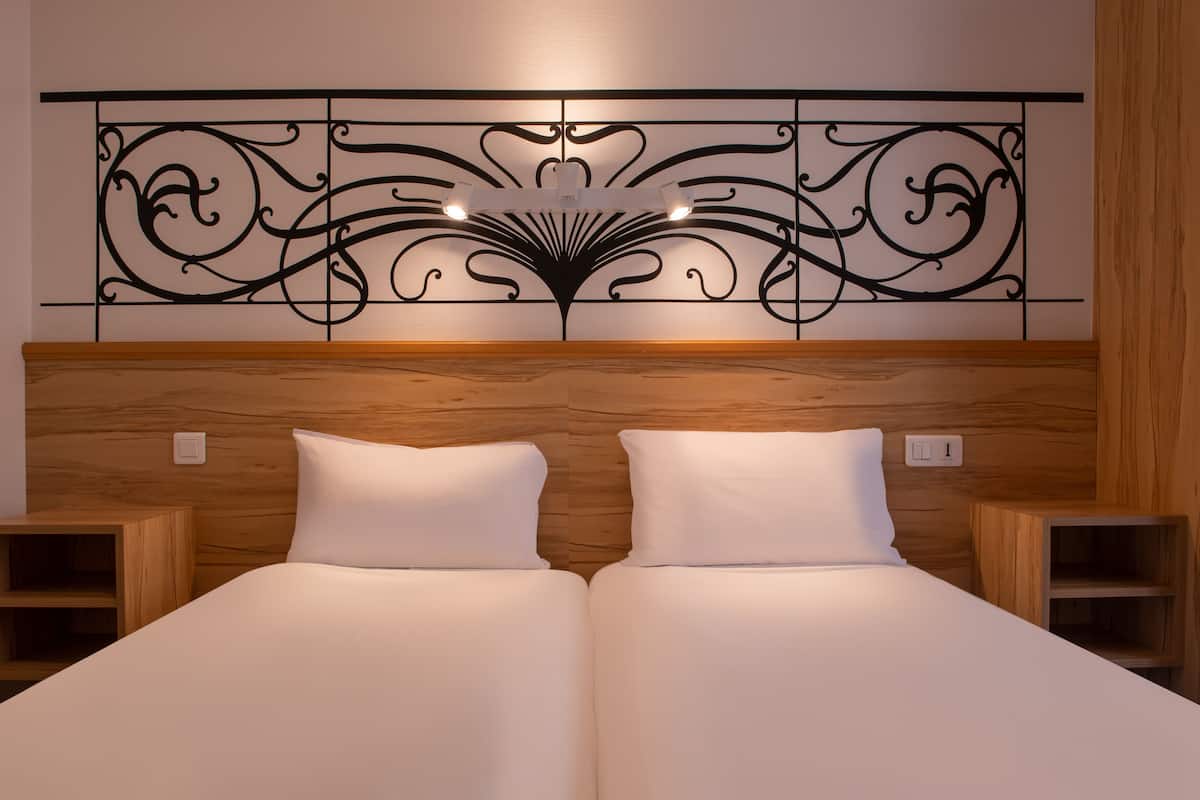 A double bed with a wooden headboard and two bedside tables.