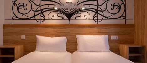 A double bed with a wooden headboard and two bedside tables.