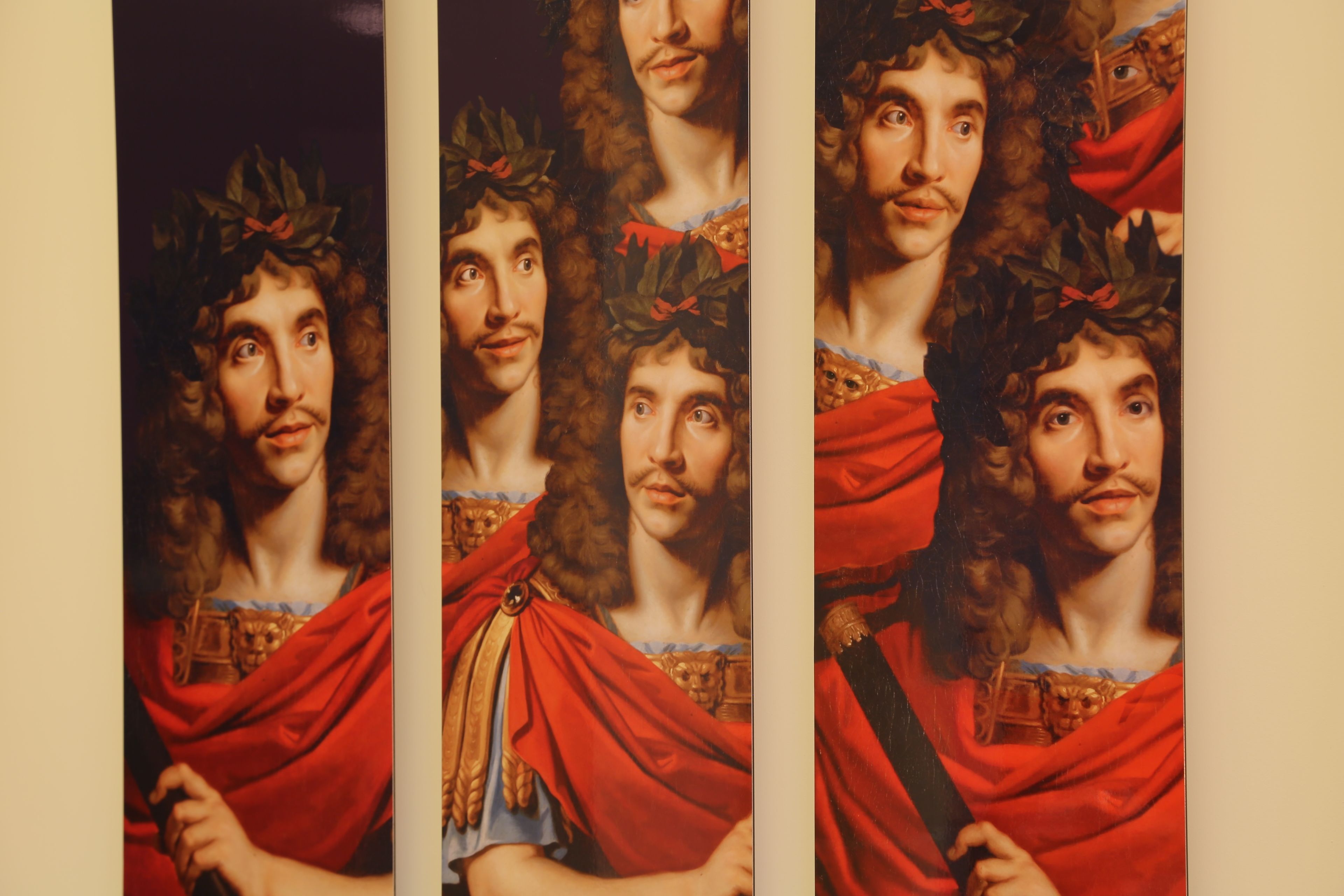 Un portrait d’une personne vêtue d’une robe rouge et portant une ceinture dorée, entourée de plusieurs copies identiques.