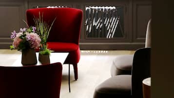 Una sala de estar moderna con un sillón rojo, un sillón marrón y una mesita con un florero.