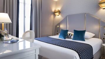 Una habitación de hotel con una cama grande, un escritorio y una silla.