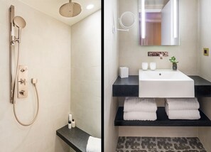Een moderne badkamer met douche, wastafel en spiegel.