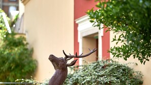 A bronze deer sculpture in a garden setting with a building in the background. - Best Western Saint Louis - Grand Paris Vincennes (Vincennes)