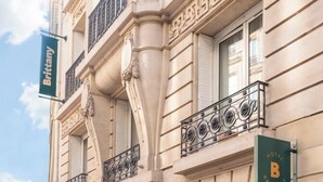 A historic building with a classic facade, a prominent entrance, and a sign indicating it is a hotel. - Hôtel Brittany Opéra (Paris)