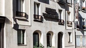 A hotel with a modern facade, multiple balconies, and a clear sign indicating its name. - VLH Montparnasse Eiffel (Paris)