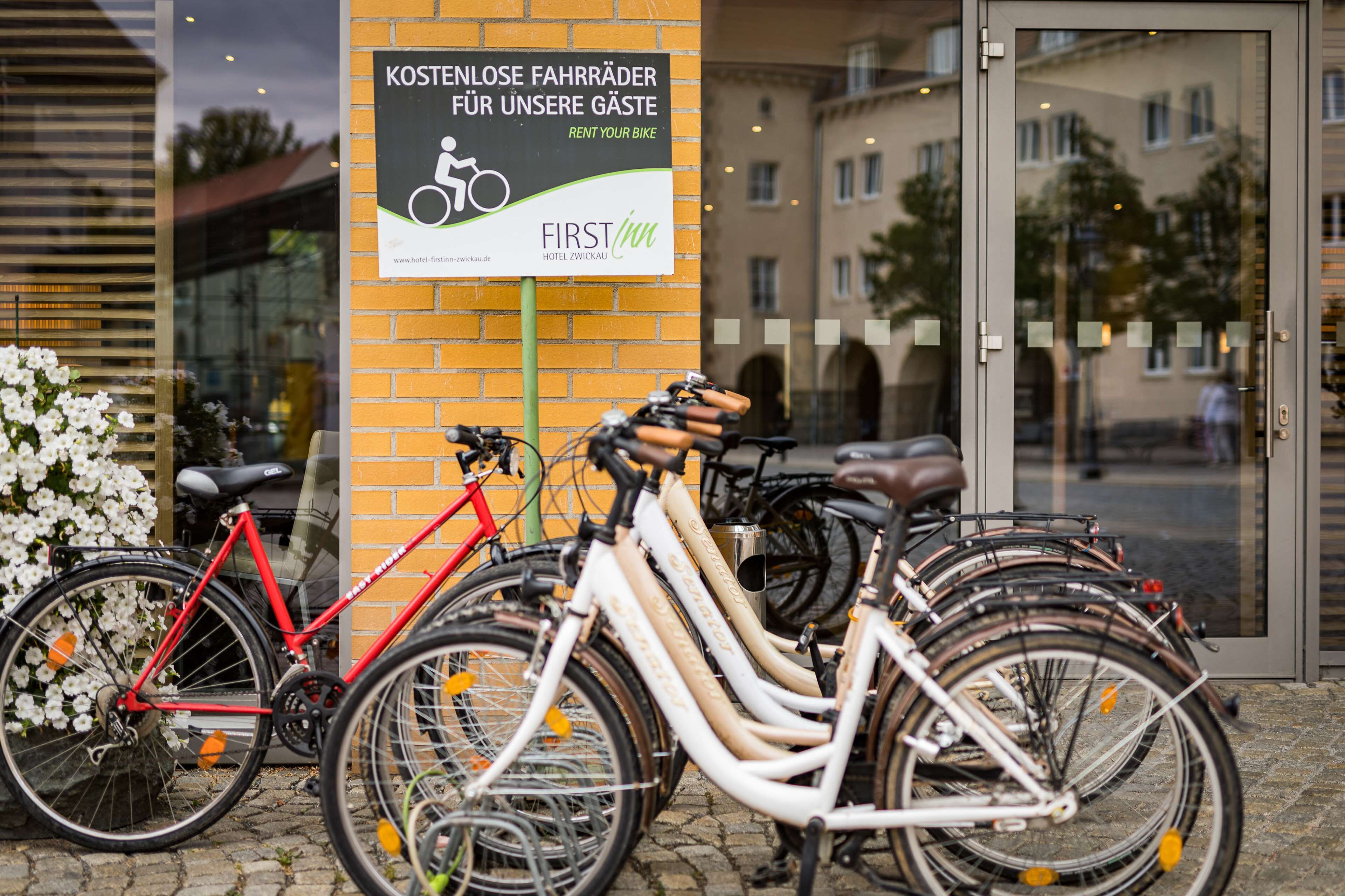 Entrada de hotel con un cartel que ofrece alquiler de bicicletas.