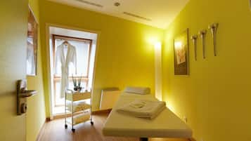 Relax in a cozy space with a comfortable examination table, a radiator for warmth, and a window with blinds for natural light control.