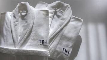 A set of white towels with the logo "NH Hotels" on them.