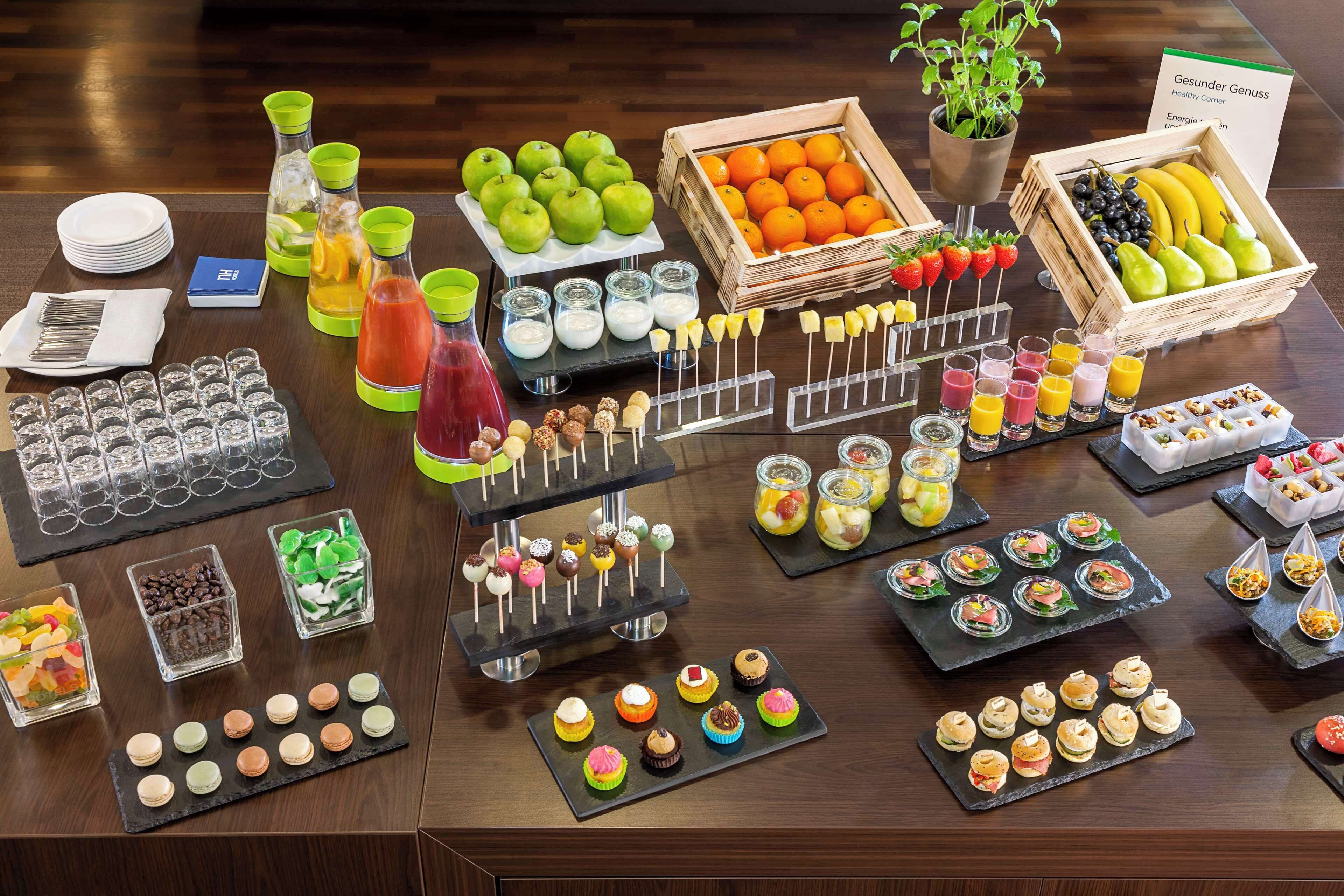 A buffet table with various food items, including fruits, juices, and desserts.