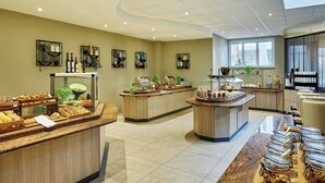 A hotel breakfast area with multiple serving stations, a buffet with various food items, and a coffee station. - Courtyard by Marriott Schwerin (Schwerin)