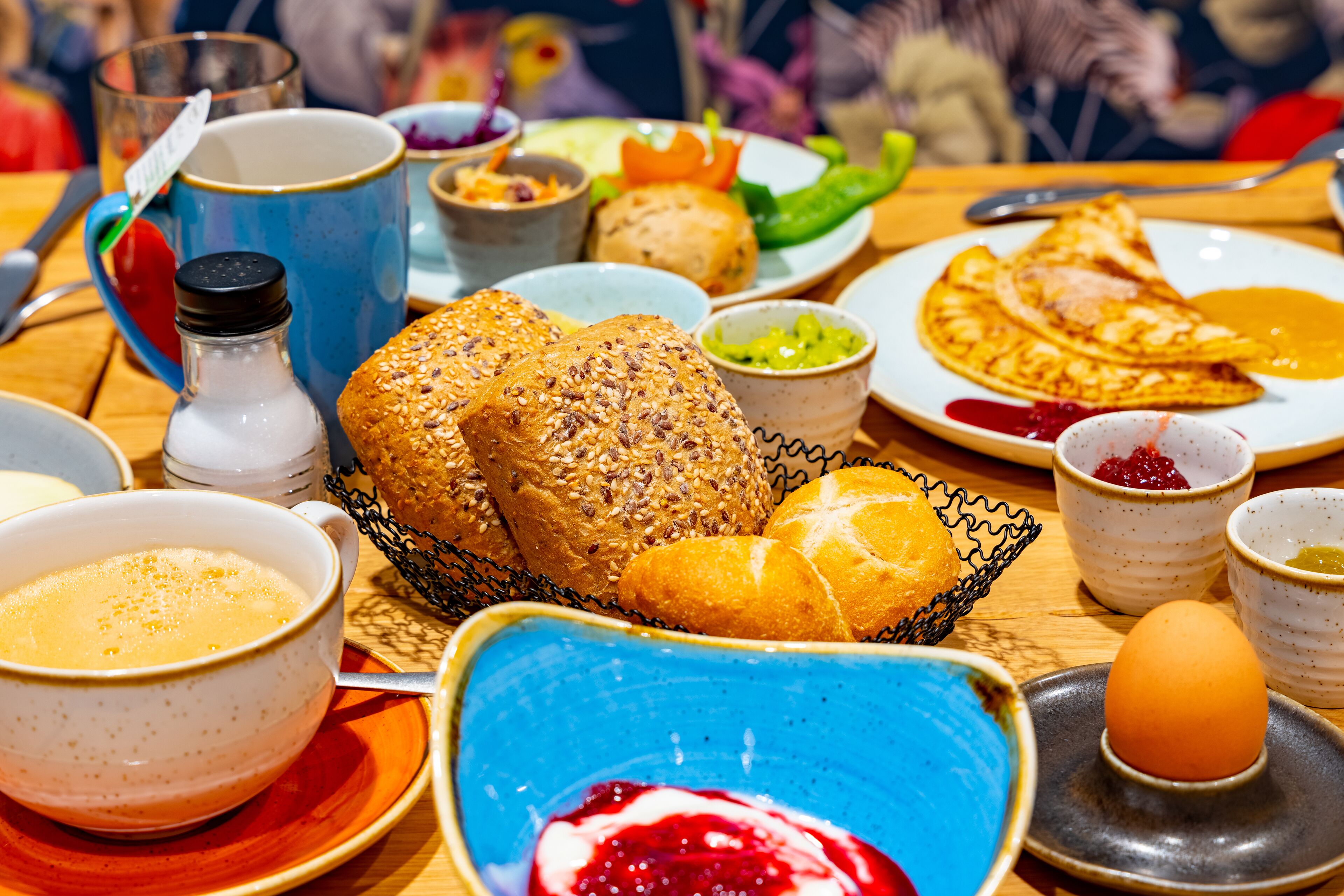 Une table de petit-déjeuner avec divers aliments, notamment du pain, des œufs et des condiments.