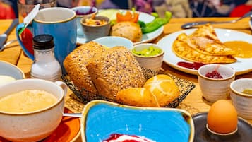 Een ontbijttafel met diverse etenswaren, zoals brood, eieren en toevoegingen.