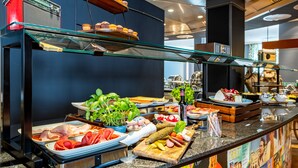 A buffet with various food items including meats, cheeses, and fruits. - mightyTwice Hotel Dresden (Dresden)