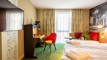 Una habitación de hotel con una cama, un escritorio con computadora, una silla, un piano y una pared con diseño de notas musicales.