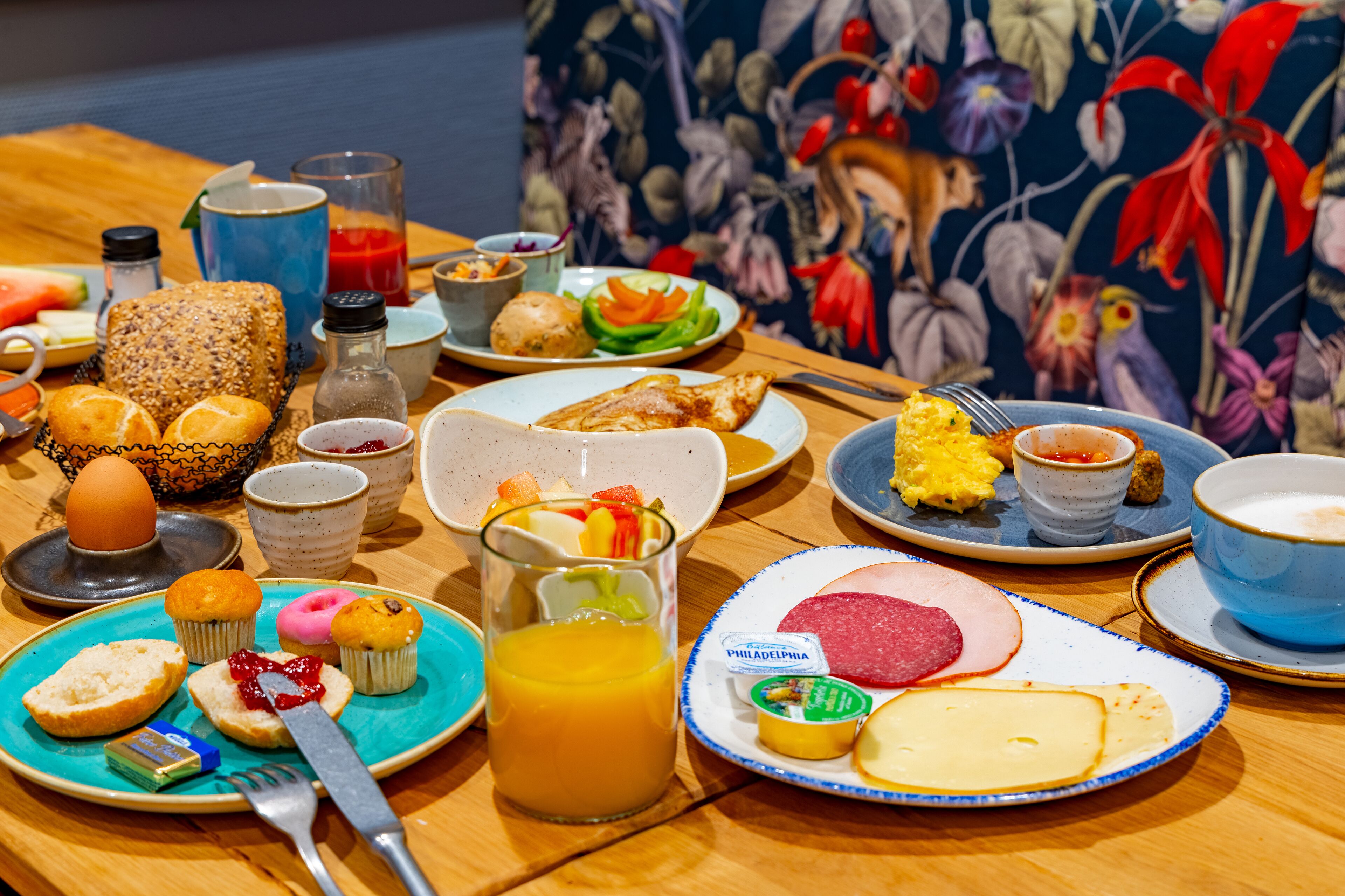 A breakfast table with various food items and drinks.