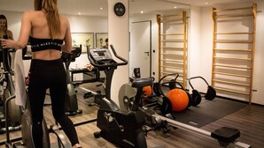 A gym with exercise equipment, a treadmill, and a mirror. - ARA-Hotel Comfort (Ingolstadt)