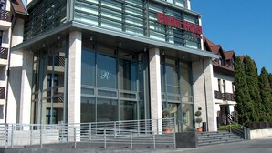 Un moderno edificio de hotel con amplios ventanales y un llamativo letrero que dice 'Rubin Hotel'.