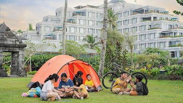 Guests can enjoy gatherings around the outdoor tent in the hotel's lush surroundings.