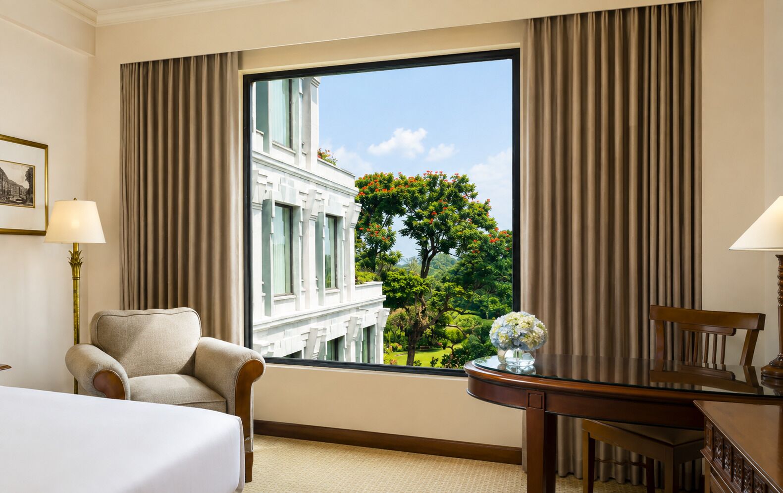 A hotel room with a large window, a bed, a chair, a desk, and a lamp.