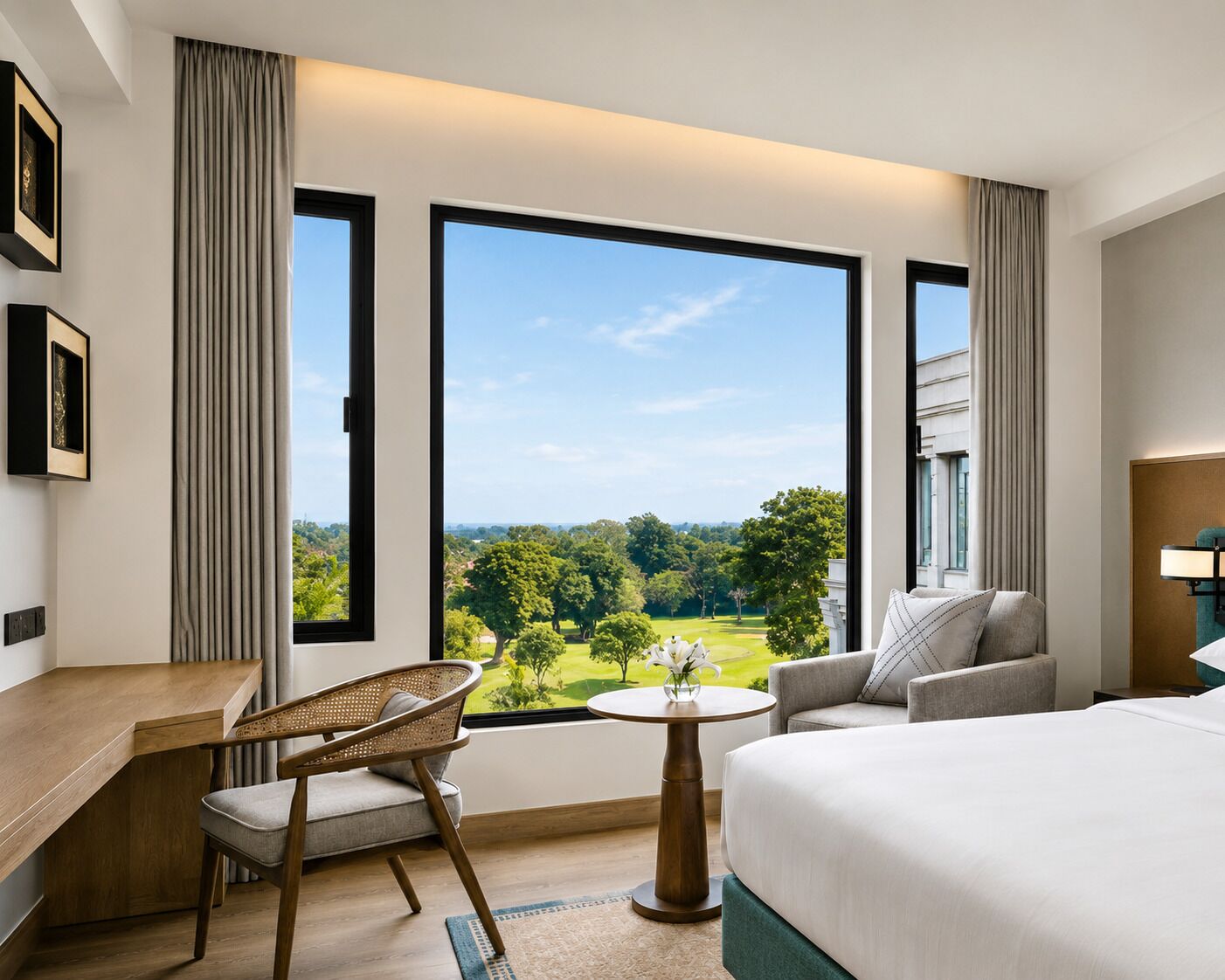 A hotel room with a large window, a bed, a desk, a chair, and a small table.
