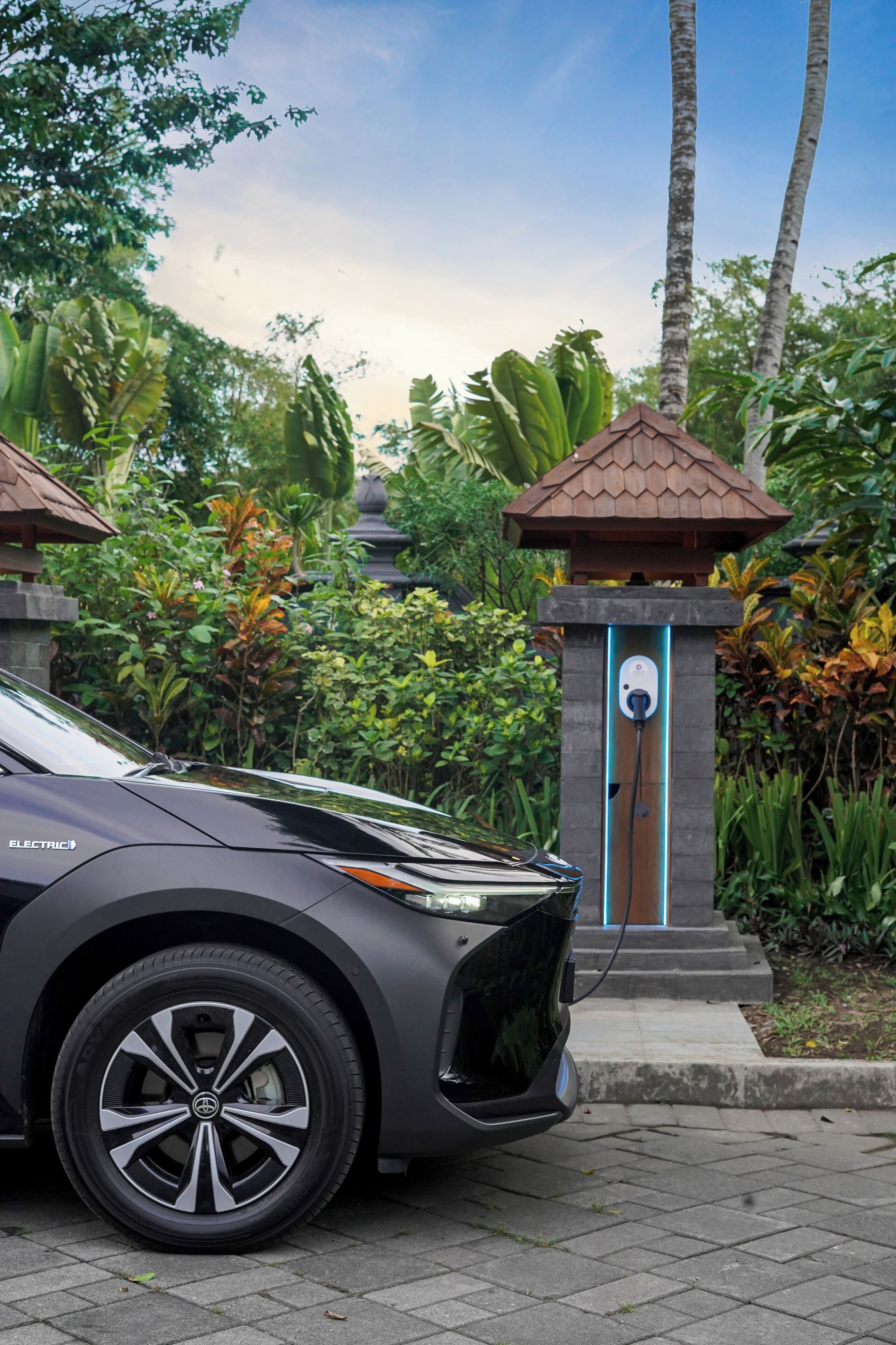 Una estación de carga para vehículos eléctricos moderna en un exuberante jardín.