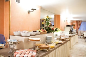 A buffet setup with various food items and a decorative centerpiece. - Hotel Giberti & SPA (Verona)