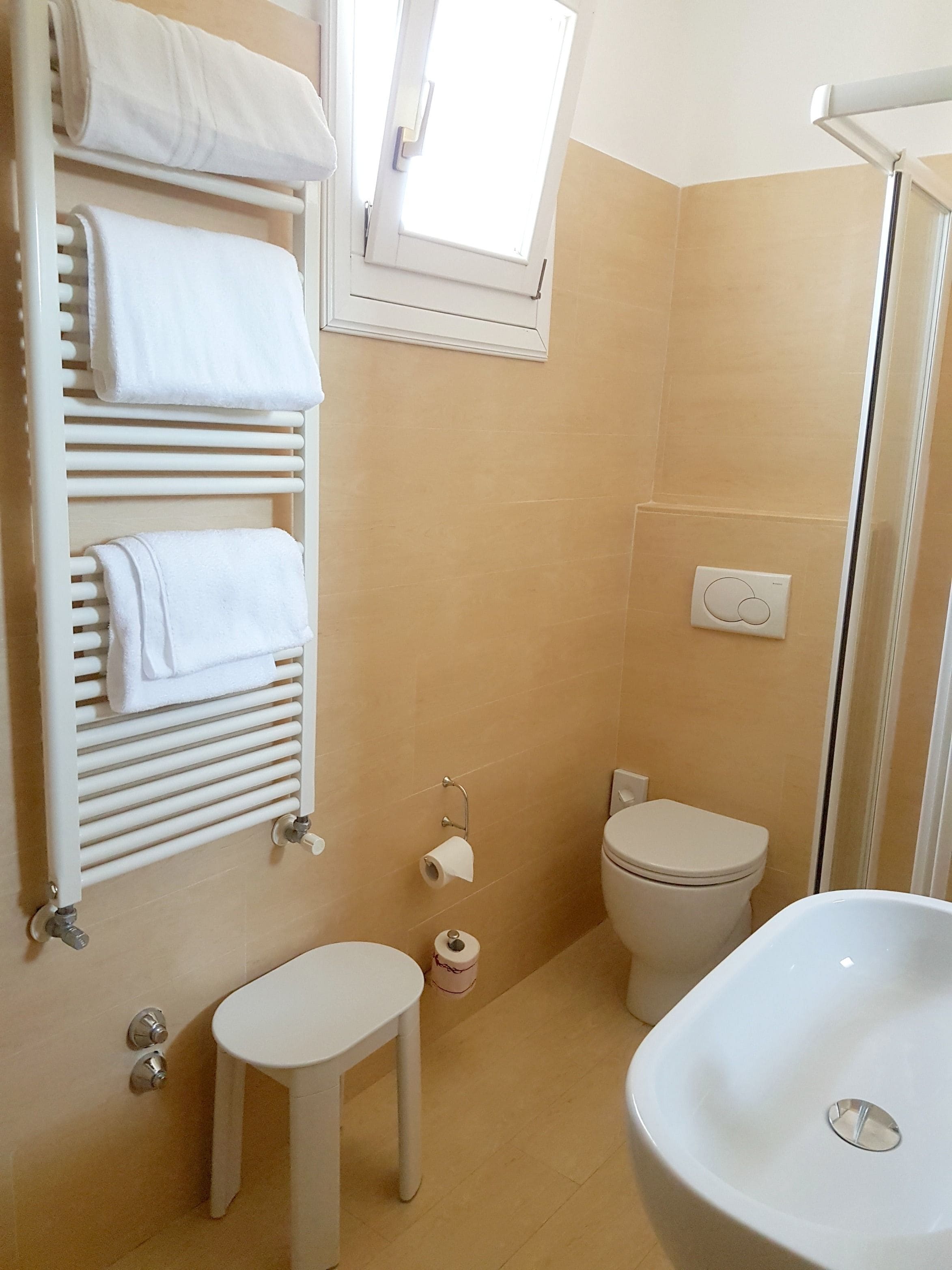 A bathroom with a white sink, toilet, and towel rack.