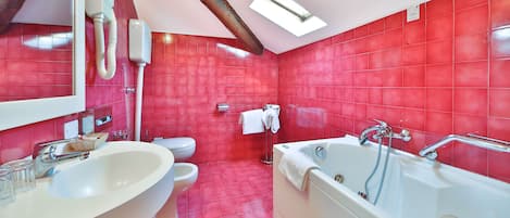 A bathroom with red tiles, a white sink, a toilet, and a bathtub.