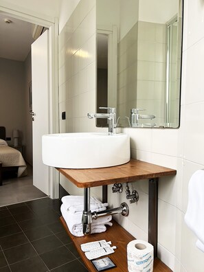Bathroom features a large sink, mirror, and towel rack.