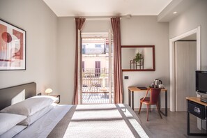 Relax in a stylish room with a comfortable bed, desk, and balcony offering a view of the outside.