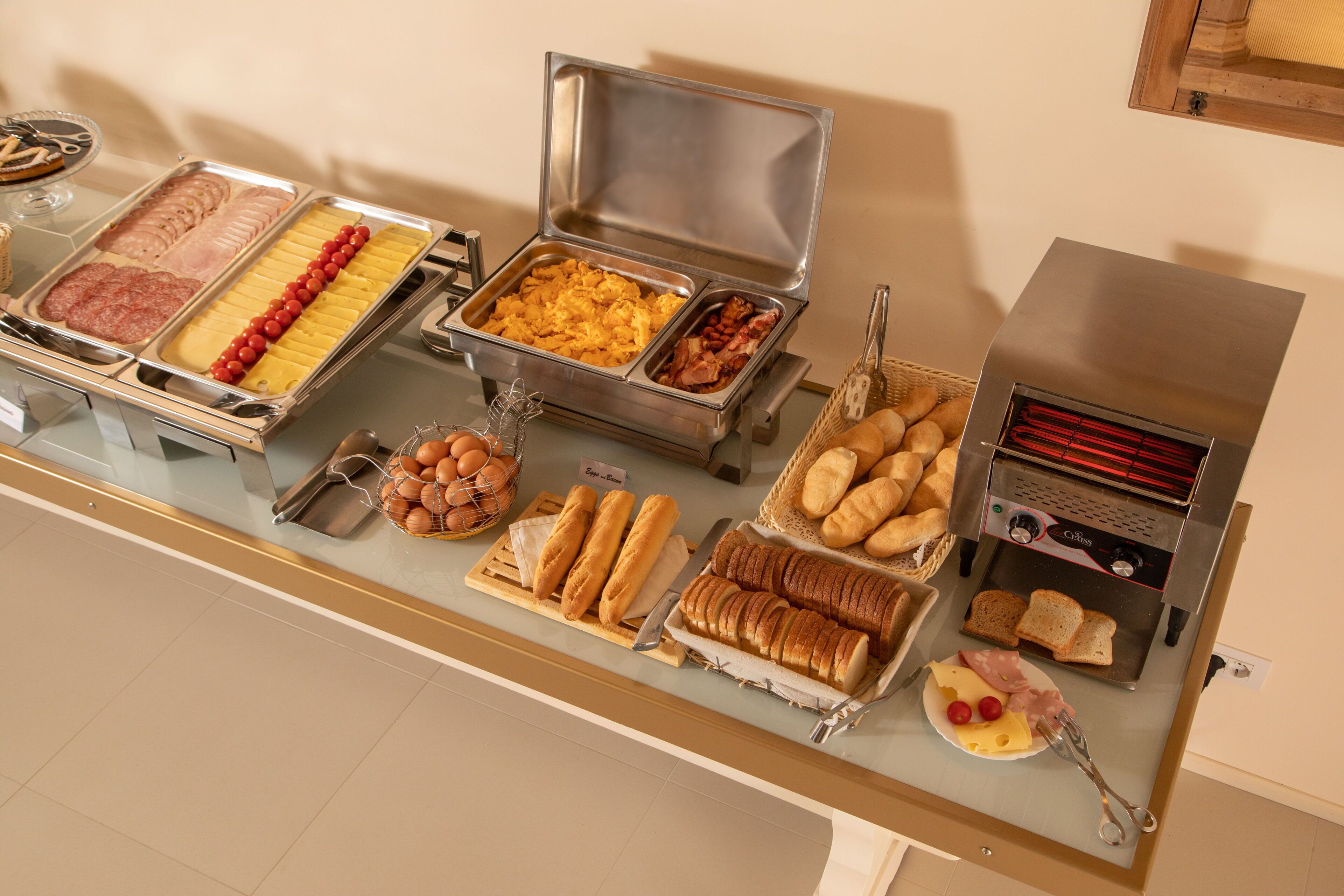 A buffet with various food items including meats, cheeses, and breads.