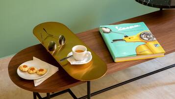 Un tavolo con un libro, una tazza di caffè, un piatto di biscotti e uno skateboard.