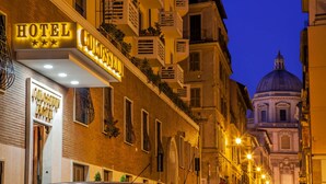 Un hotel con un letrero que dice "HOTEL COLSEUS HOTEL" y una estructura en forma de cúpula al fondo.