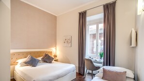 Una habitación de hotel con dos camas, un escritorio y una silla.