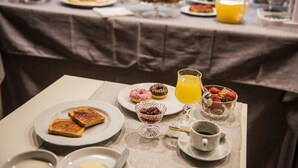 Un bufé de desayuno con diversos pasteles, frutas y bebidas sobre una mesa.