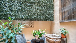 Un patio con mesa, sillas y plantas en macetas.