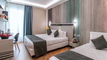 Driepersoonskamer | Luxe beddengoed, een minibar, een kluis op de kamer, een bureau