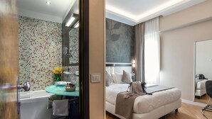 A modern hotel room with a glass-enclosed bathroom, a bed with a beige duvet, and a wooden floor. - Hotel Memphis (Rome)