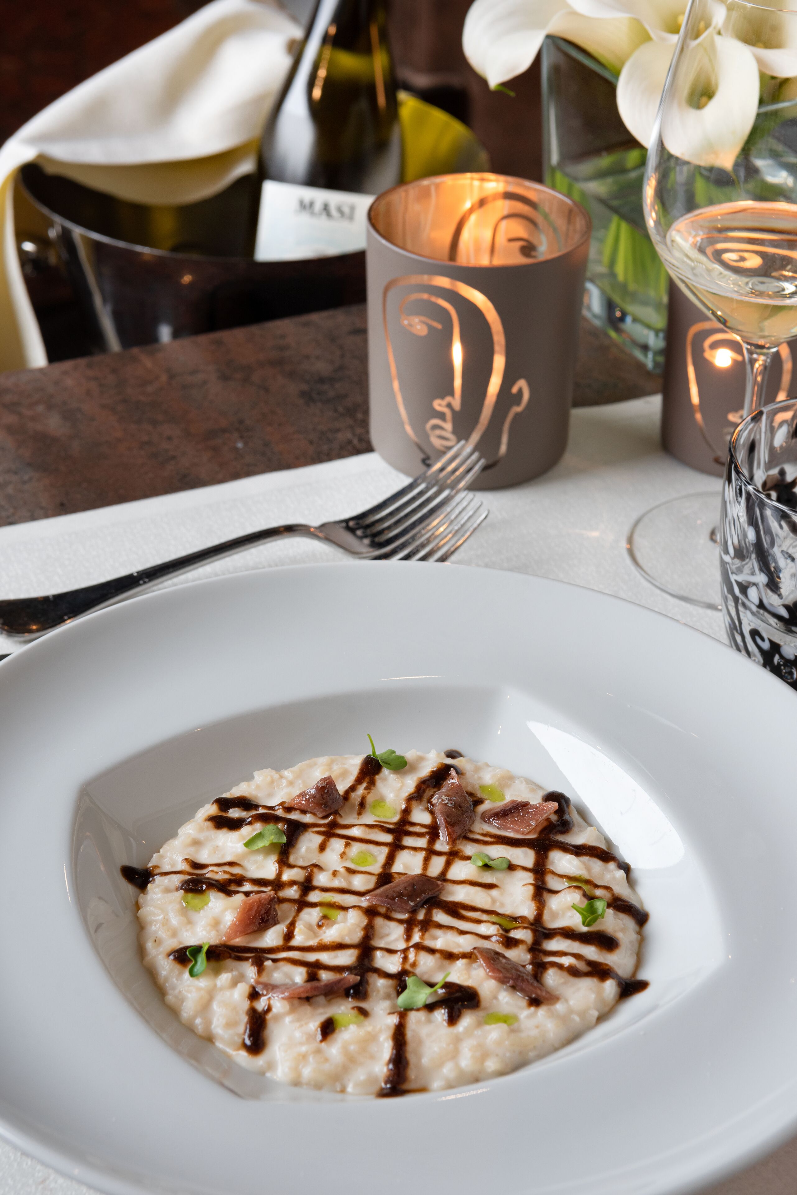 A plate of food with a fork and candle holders.