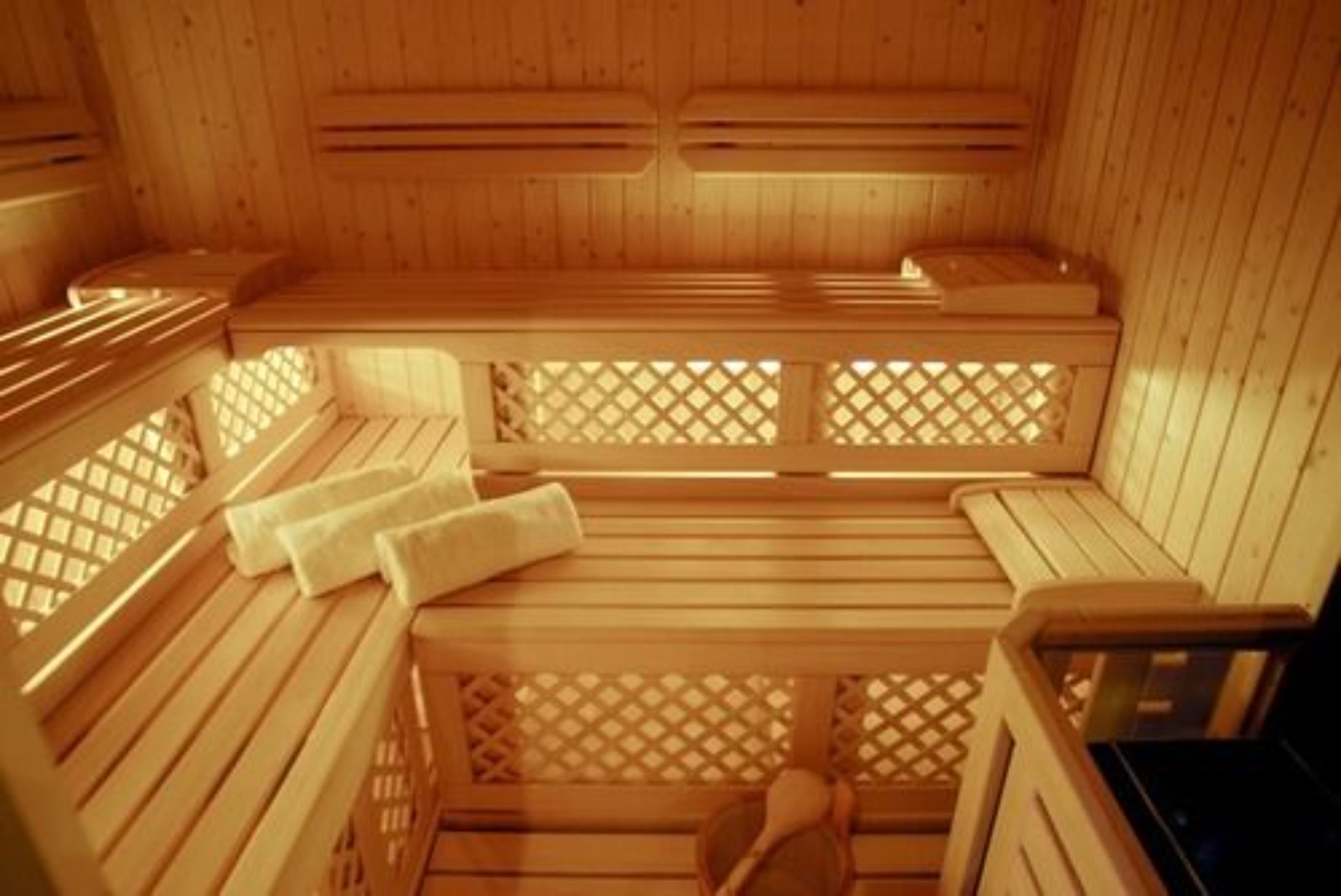 A wooden sauna with benches and benches with footrests.