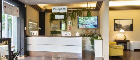 A reception area with a reception desk, a television, and a reception sign.