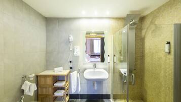 A modern bathroom with a sink, mirror, and shower.
