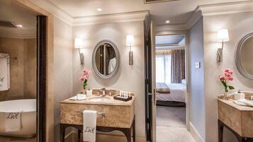 A modern bathroom with a bathtub, a vanity with a mirror, and a shower area.